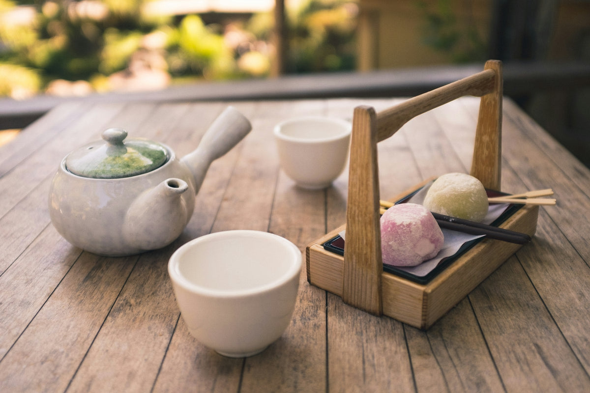 White ceramic teapot and cups on a wooden table