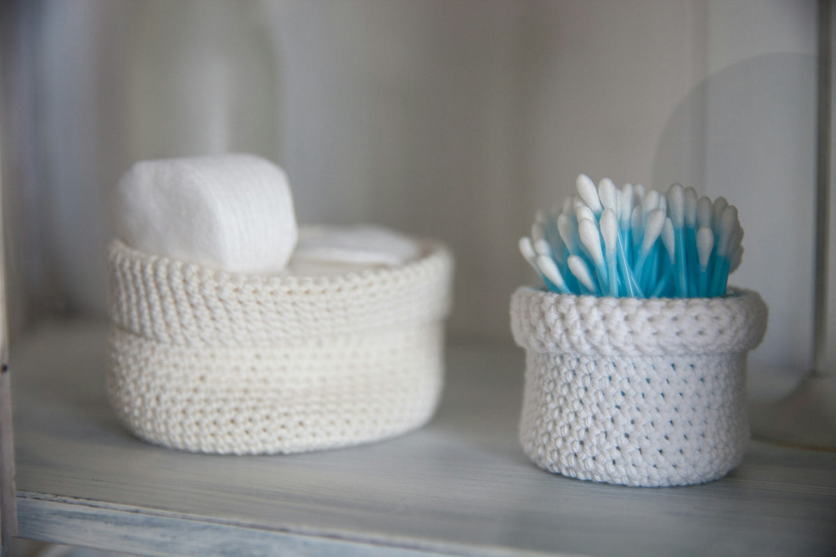 Crochet storage baskets on a bathroom shelf